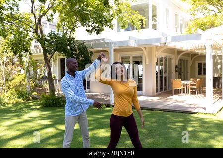Happy couple dancing in the garden Stock Photo