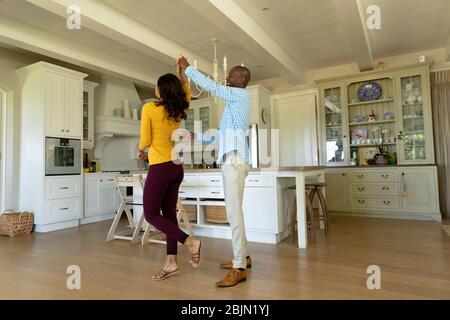 Happy couple dancing in their kitchen Stock Photo