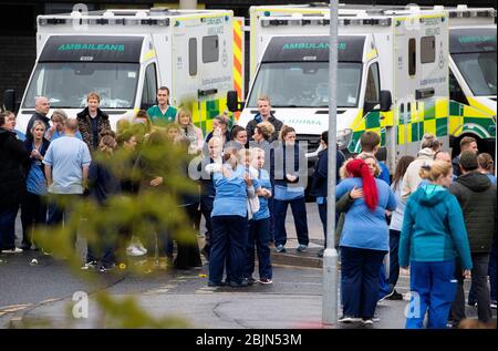 NHS staff comfort and console each other after the funeral cortege of NHS worker Jane Murphy passed the Accident and Emergency department at the Edinburgh Royal Infirmary, Edinburgh. Stock Photo