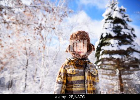 Portrait of a boy wearing a hunters cap in the snow, USA Stock Photo
