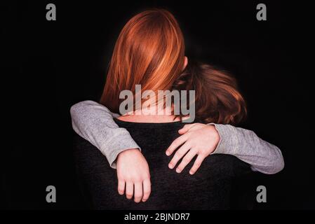 Rear view of a woman hugging her son Stock Photo