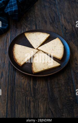 Spicy Circassian Triangle Smoked Cheese Slices on Dark Wooden Plate with Spices. Ready to Eat. Stock Photo
