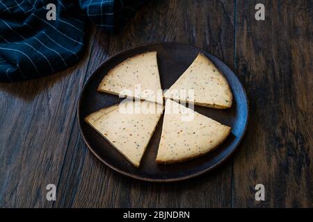 Spicy Circassian Triangle Smoked Cheese Slices on Dark Wooden Plate with Spices. Ready to Eat. Stock Photo