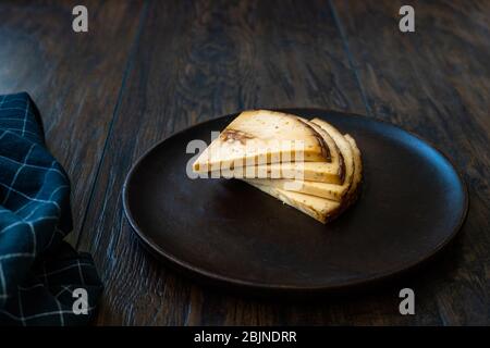 Spicy Circassian Triangle Smoked Cheese Slices on Dark Wooden Plate with Spices. Ready to Eat. Stock Photo