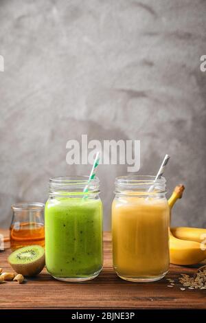 Jars with tasty protein shakes on wooden table Stock Photo