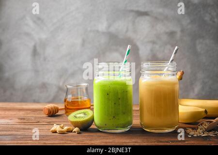 Jars with tasty protein shakes on wooden table Stock Photo