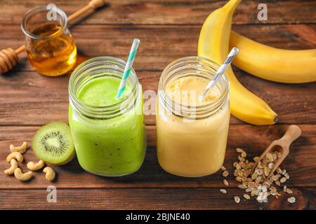 Jars with tasty protein shakes on wooden table Stock Photo