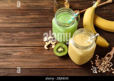 Jars with tasty protein shakes on wooden table Stock Photo