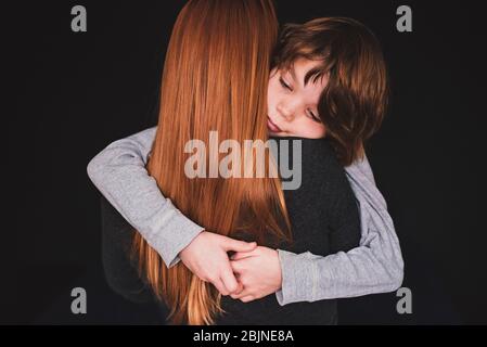 Rear view of a woman hugging her son Stock Photo