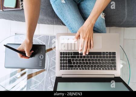 Graphic designer woman smart working on computer at home - Young female drawing design with interactive pen and laptop Stock Photo