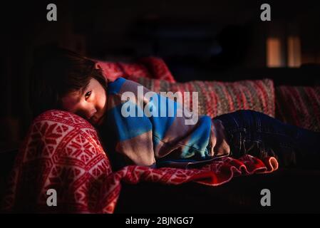 Boy lying on a sofa relaxing Stock Photo
