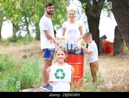 Family throwing garbage into litter bin outdoors. Recycling concept Stock Photo