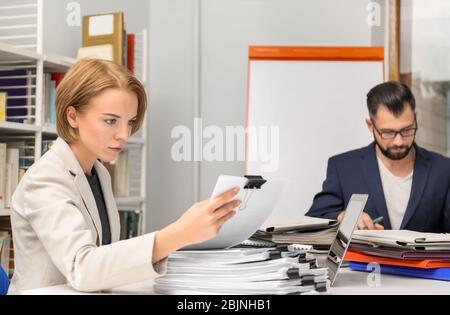 Man and woman working with documents at table in archive Stock Photo