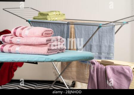 Housework concept. Ironing towels on ironing board Stock Photo