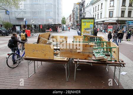 Hamburg, Germany. 28th Apr, 2020. Stacked tables and chairs are standing in front of a restaurant in Ottensen (Hamburg-Altona). Most of the restaurants, cafés and pubs in the Hanseatic city have closed due to the corona crisis. Credit: Bodo Marks/dpa/Alamy Live News Stock Photo
