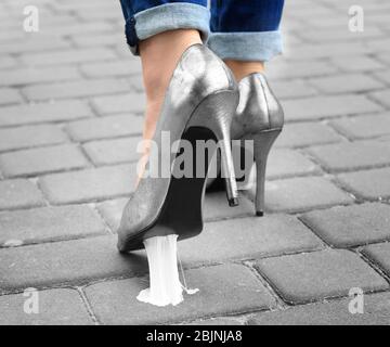 Foot stuck into chewing gum on street. Concept of stickiness Stock Photo