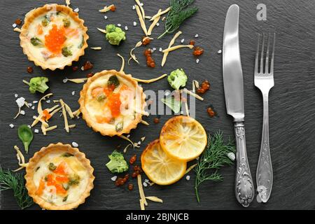 Composition with tasty salmon tartlets on black background Stock Photo