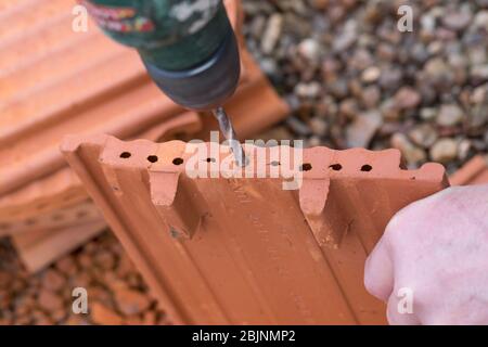 nesting aid for wild bees, interlocking pantile, step 2: edge of the holes smoothing by a drill, Germany Stock Photo