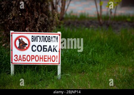 Ukraine, Kyiv - April 30, 2020: a sign on the lawn Dogs are not allowed . The inscription in Ukrainian. Park, public place. A flower bed with grass Stock Photo