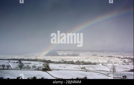Rainbow over Wensleydale in a snow shower. North Yorkshire, UK. Stock Photo