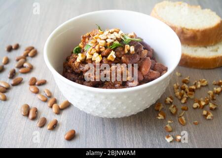 Traditional Georgian vegan kidney beam stew lobio with chopped walnuts and parsley served in a bowl with slices of bread Stock Photo