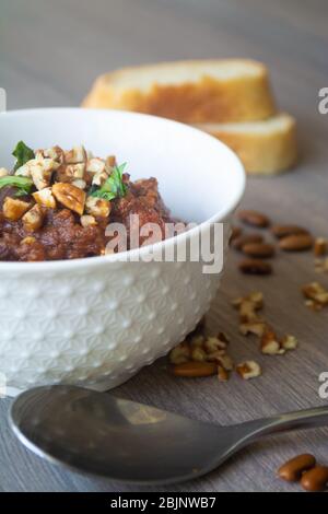 Traditional Georgian vegan kidney beam stew lobio with chopped walnuts and parsley served in a bowl with slices of bread Stock Photo