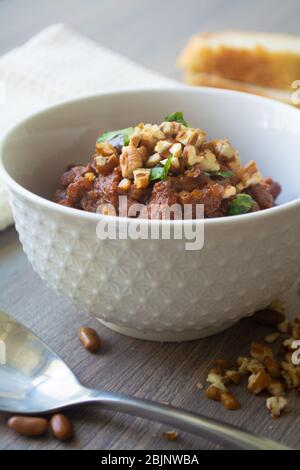 Traditional Georgian vegan kidney beam stew lobio with chopped walnuts and parsley served in a bowl with slices of bread Stock Photo