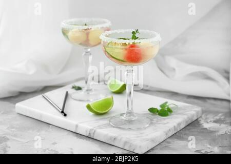 Cocktail glasses with melon ball drink on table Stock Photo