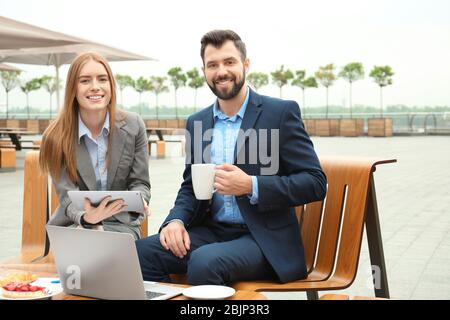 Young marketing managers working in cafe outdoors Stock Photo