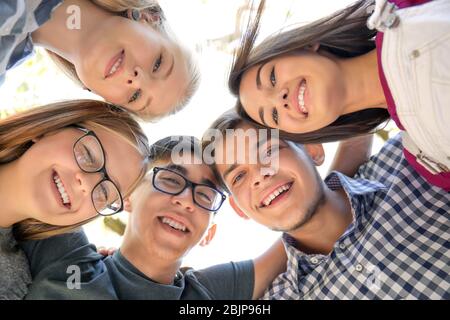 Happy teenagers joined in circle outdoors Stock Photo