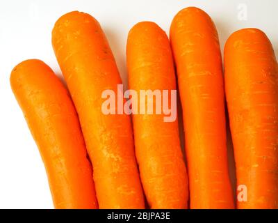 Five fresh orange carrots on a white background Stock Photo