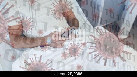 Digital illustration of a patient using his smartphone in hospital bed over coronavirus Covid19 cell Stock Photo