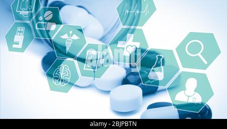 Digital illustration of medical icons over medical pills lying outside Stock Photo