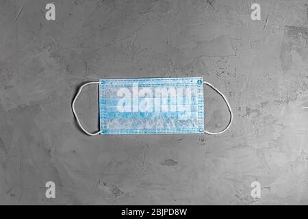 blue disposable mask on a grey concrete background. flat lay. top view Stock Photo