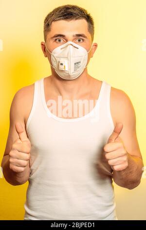 Wuhan, China - April 21 2020: Patient man in medical mask on self isolation during quarantine and coronavirus pandemic stands with arms crossed new. S Stock Photo