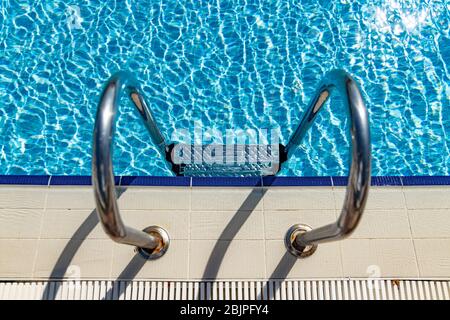 Grab bars ladder in the swimming pool Stock Photo