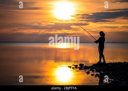 Premium Photo  Woman fishing on Fishing rod spinning at sunset background