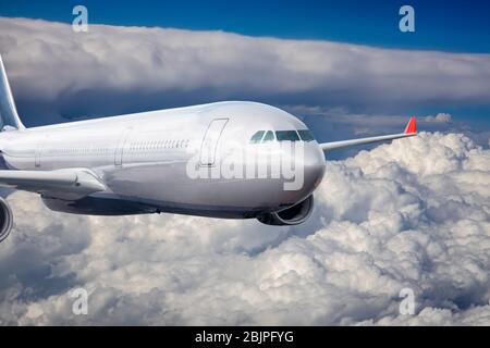 Passenger Airliner flying in the clouds Stock Photo