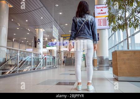 Female passenger at the airport looks at the Board about flight cancellations Stock Photo