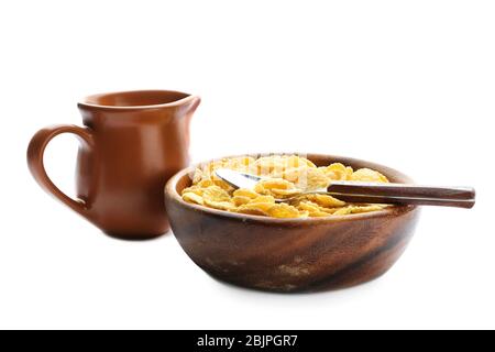 Bowl with corn flakes and jug of milk on white background Stock Photo