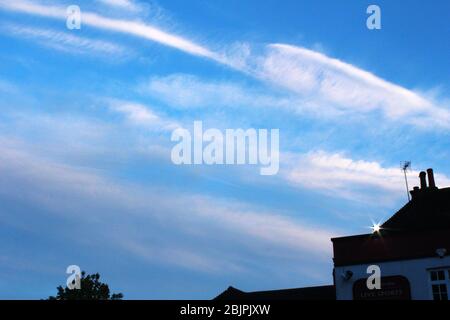 Pale pink clouds in a bright blue sky in Manchester, England Stock Photo