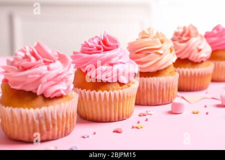 Many yummy cupcakes on table Stock Photo
