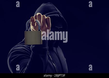 Hacker with lock on dark background Stock Photo