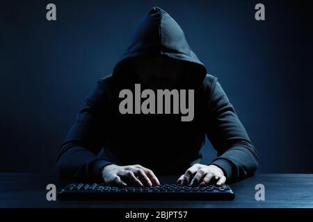 Hacker using keyboard on dark background Stock Photo