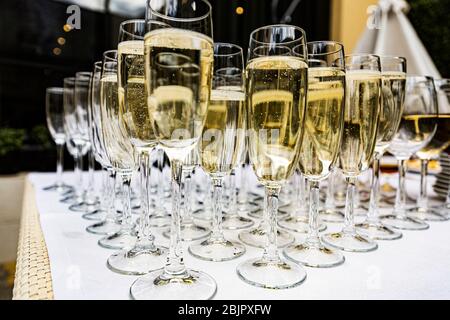 Glasses with champagne at a buffet at a wedding party. Secular reception, new year, wedding. Soft focus. Glasses with Proseko at the holiday. Many gla Stock Photo