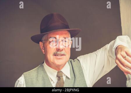 Front view of 1940s man in smart waistcoat and fedora, trilby hat, isolated outdoors, 1940s wartime WWII summer event, UK. Stock Photo