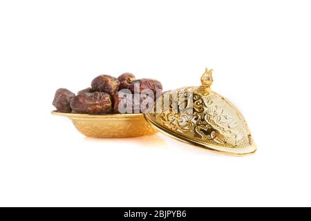 Golden bowl isolated on white background.Ramadan Kareem Breaking the fast by eating Tamar Dates Stock Photo