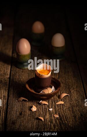 Fresh brown eggs on rustic table. Broken egg with yolk. Stock Photo