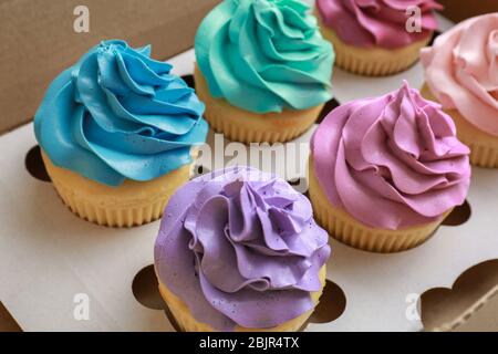 Tasty colorful cupcakes in cardboard box, closeup Stock Photo