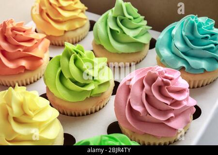 Tasty colorful cupcakes in cardboard box, closeup Stock Photo